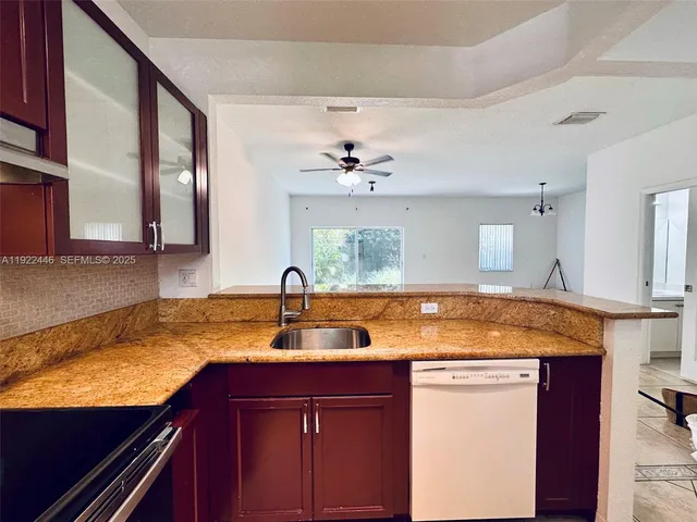 a kitchen with a granite countertop sink and cabinets