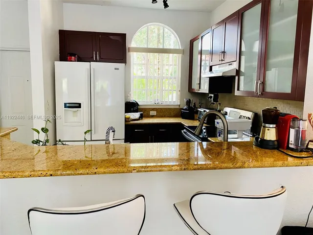 a kitchen with stainless steel appliances granite countertop a sink a stove and a microwave