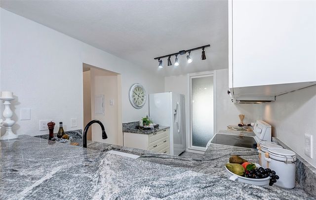 a kitchen with granite countertop a sink stove and cabinets