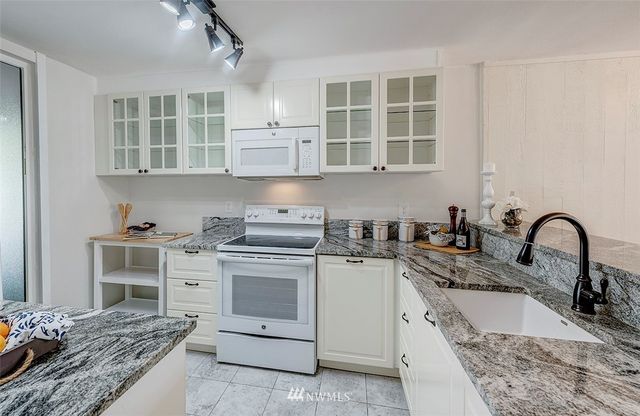 a kitchen with stainless steel appliances granite countertop a sink and cabinets