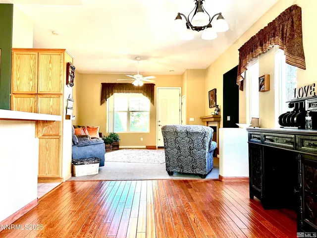 a living room with stainless steel appliances kitchen island granite countertop wooden floor and a large window