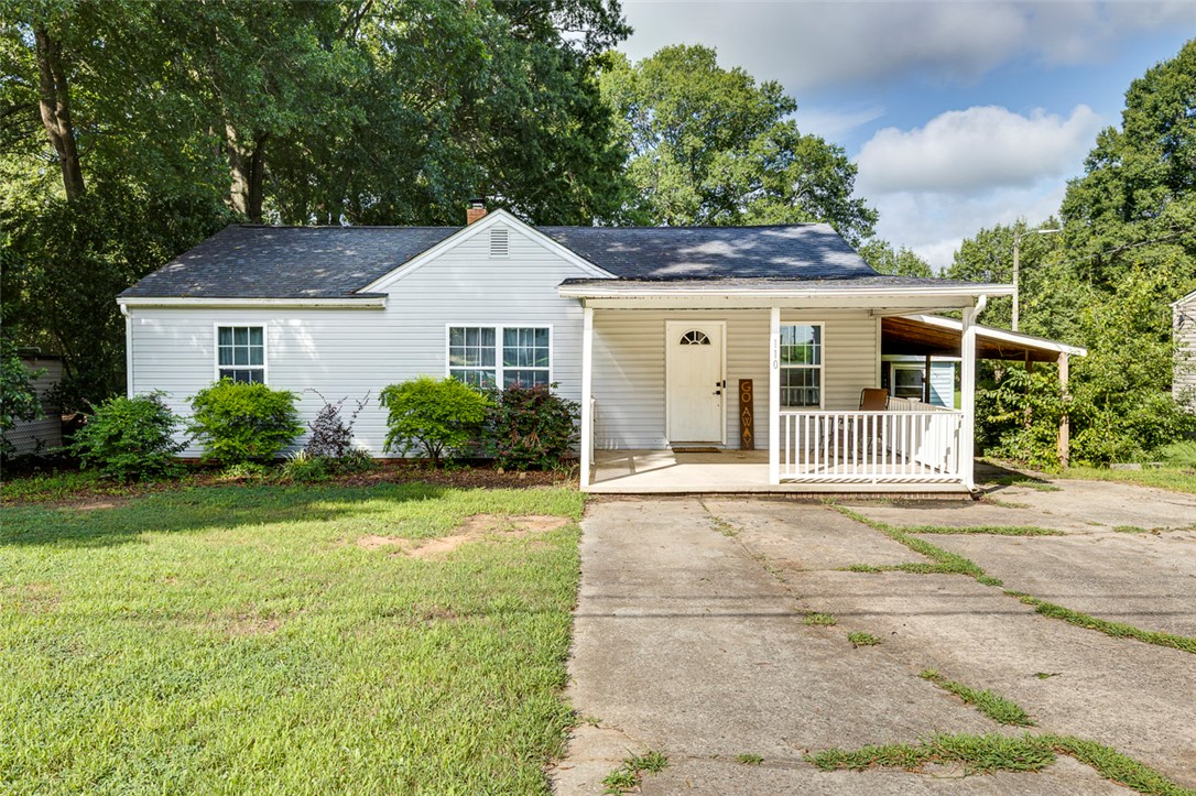 110 Avondale Road Anderson, SC 29624 - Photo 1 of 26 A charming single-family home features a welcoming covered porch, mature landscaping, and an attached carport.