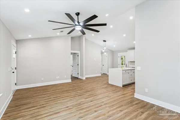 a view of a kitchen with wooden floor and a ceiling fan