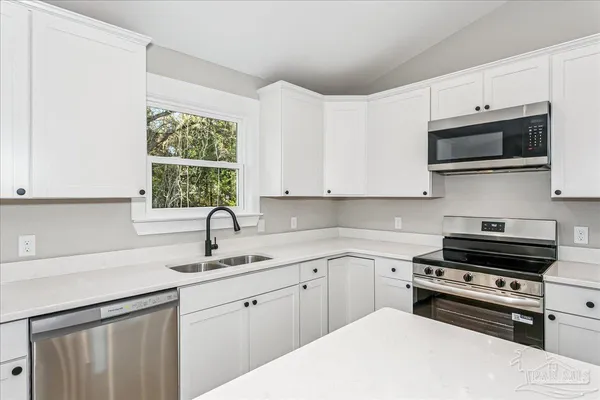 a kitchen with appliances a sink and a window