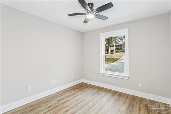 an empty room with a window and a fan