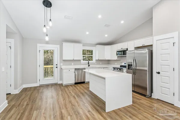 a kitchen with white cabinets and stainless steel appliances