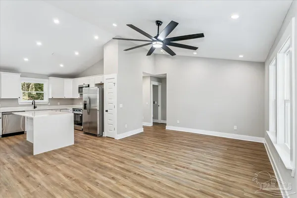 a view of a kitchen with a sink refrigerator and wooden floor