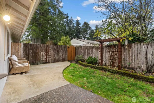 a view of a backyard with wooden fence and a large tree