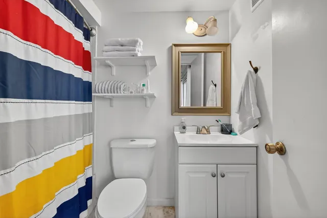 a bathroom with a sink a toilet and mirror