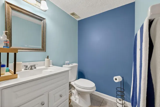 a bathroom with a toilet sink vanity and mirror