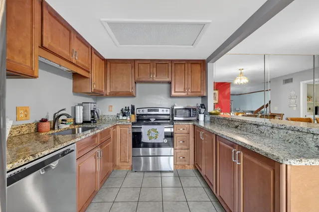 a kitchen with stainless steel appliances granite countertop a sink stove and cabinets