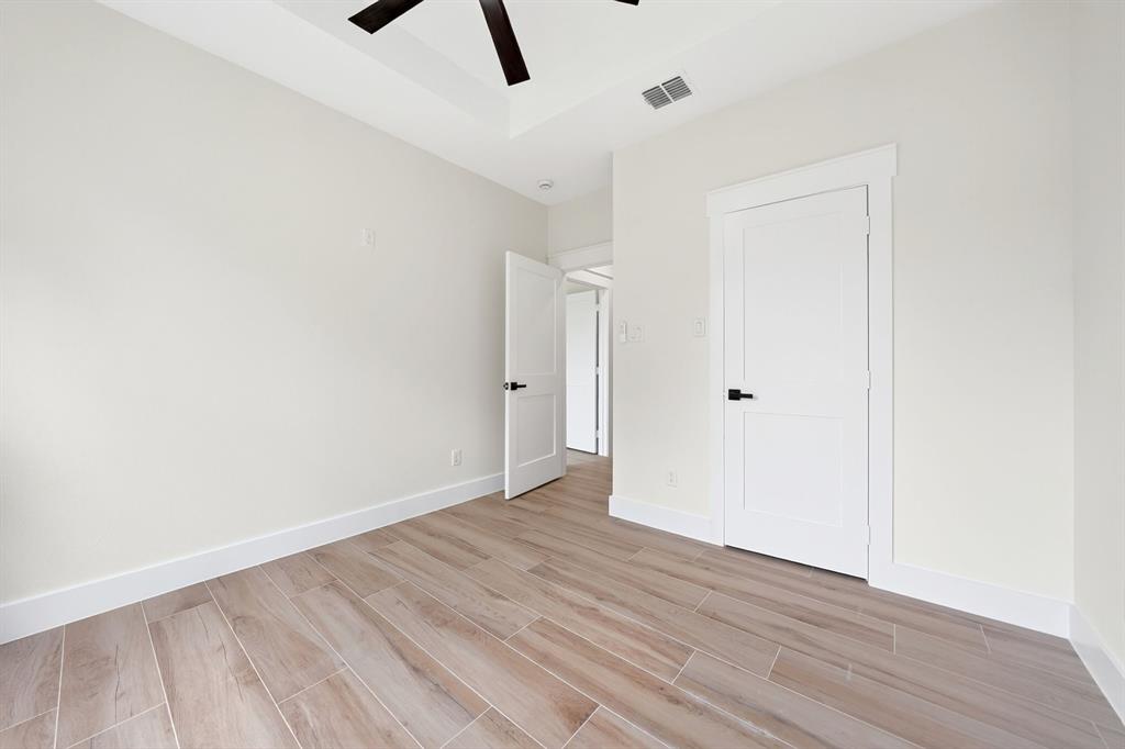 120 Springwood Road Enchanted Oaks, TX 75156 - Photo 32 of 37 Tray ceiling with a ceiling fan, wood-finish tile flooring, and white interior doors with dark hardware