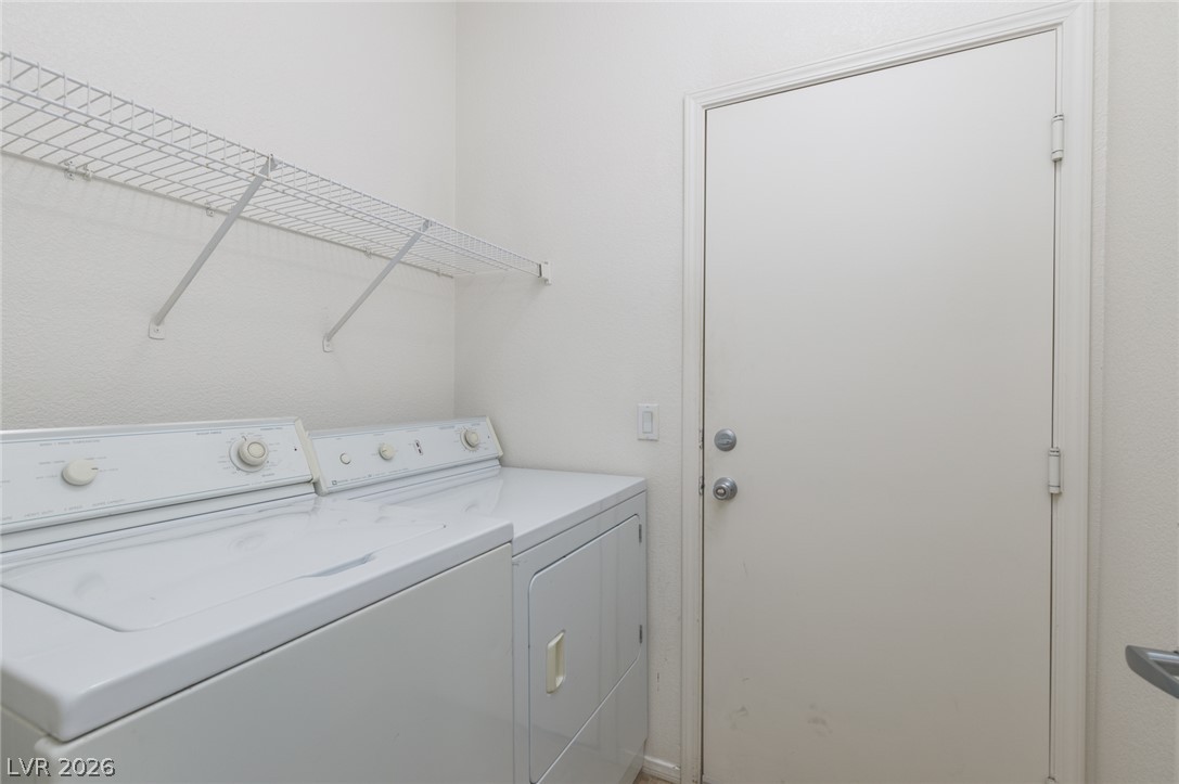 787 Rise Canyon Drive Henderson, NV 89052 - Photo 15 of 22 A dedicated laundry room with convenient built-in shelving above a washer and dryer.