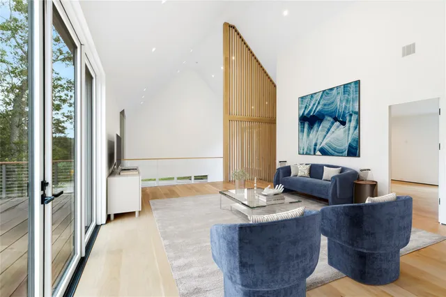 a living room with couches a coffee table and a large window with outer view