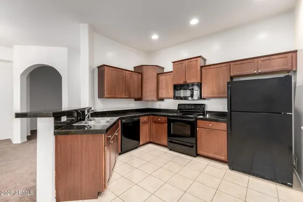 a kitchen with stainless steel appliances granite countertop a refrigerator sink and stove