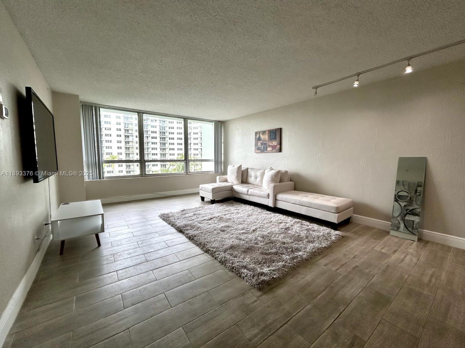 1500 Bay Road, Unit 558S Miami Beach, FL 33139 - Photo 17 of 18 a living room with furniture and a flat screen tv