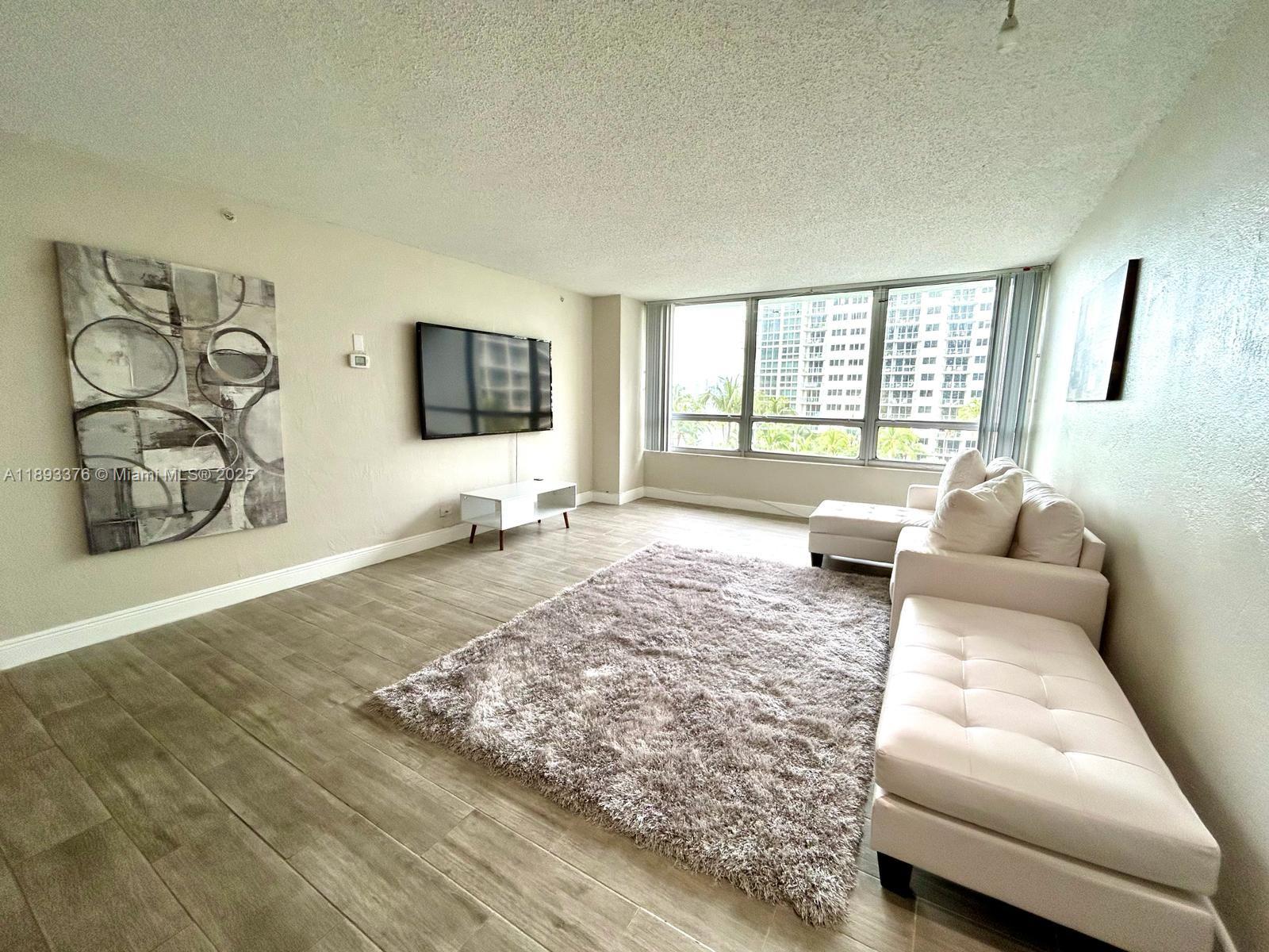 1500 Bay Road, Unit 558S Miami Beach, FL 33139 - Photo 18 of 18 a living room with furniture and a flat screen tv
