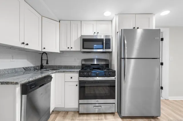 a view of kitchen island wooden floor cabinetry and a window
