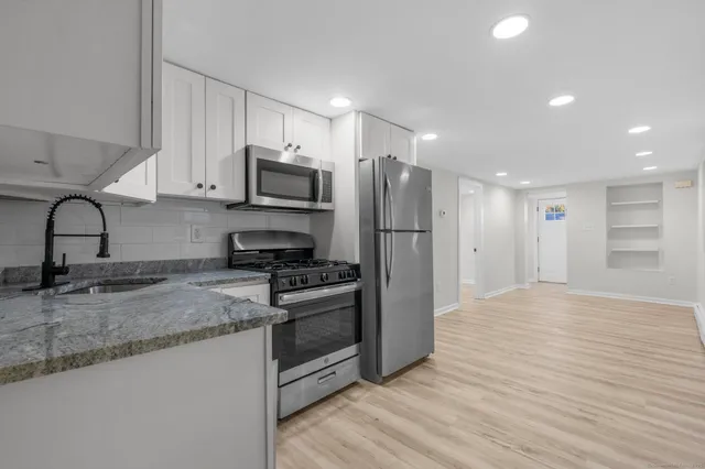 a kitchen with stainless steel appliances granite countertop a stove a refrigerator and a microwave