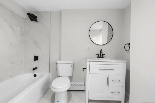 a bathroom with a sink a mirror a toilet and a bathtub