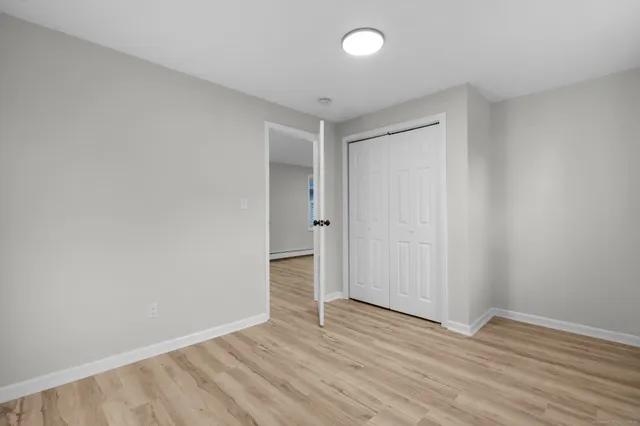a view of a small space with wooden floor and a window