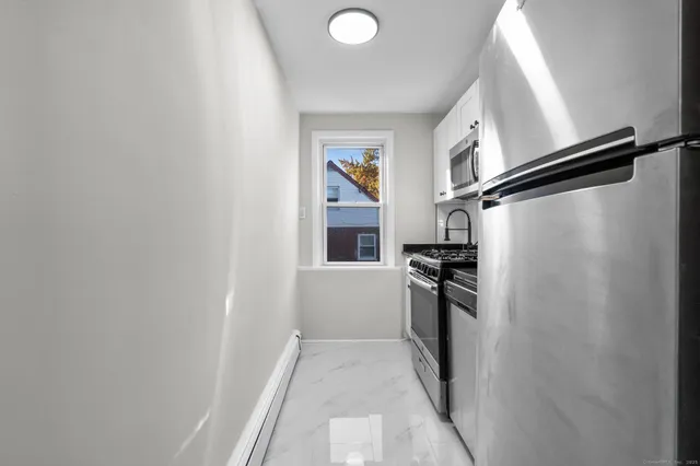 a kitchen with stainless steel appliances granite countertop a stove and a microwave