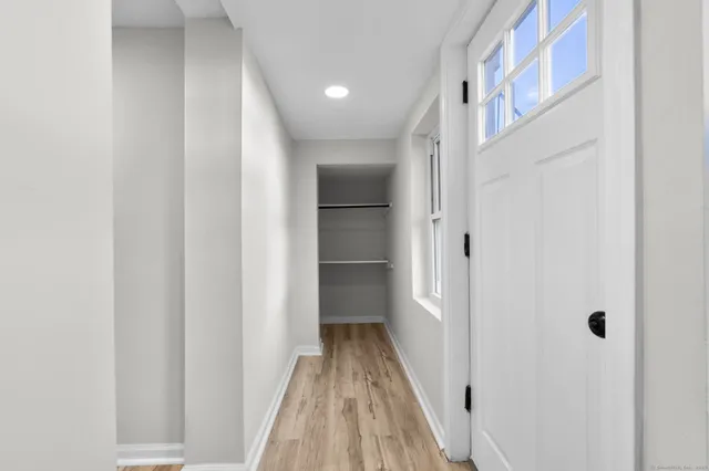 a view of a hallway with wooden floor and entryway