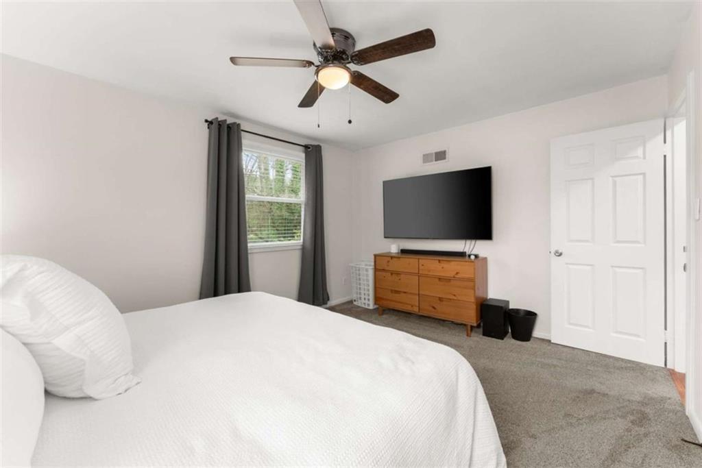 114 Duke Street Jefferson, GA 30549 - Photo 30 of 46 a bedroom with bed tv and wooden floor