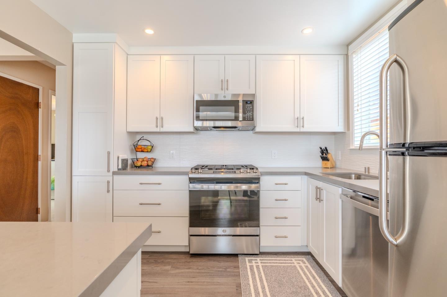 42 Eastridge Circle Pacifica, CA 94044 - Photo 13 of 33 a kitchen with white cabinets and stainless steel appliances
