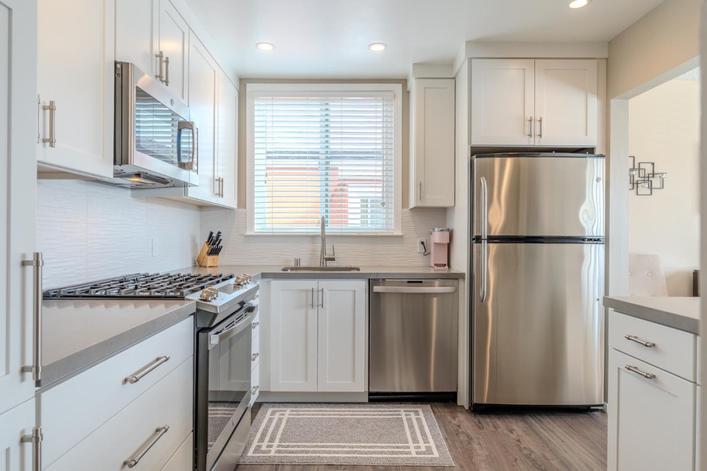 42 Eastridge Circle Pacifica, CA 94044 - Photo 15 of 33 a kitchen with stainless steel appliances granite countertop a refrigerator sink and white cabinets
