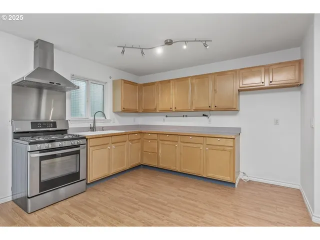 a kitchen with cabinets appliances and a sink