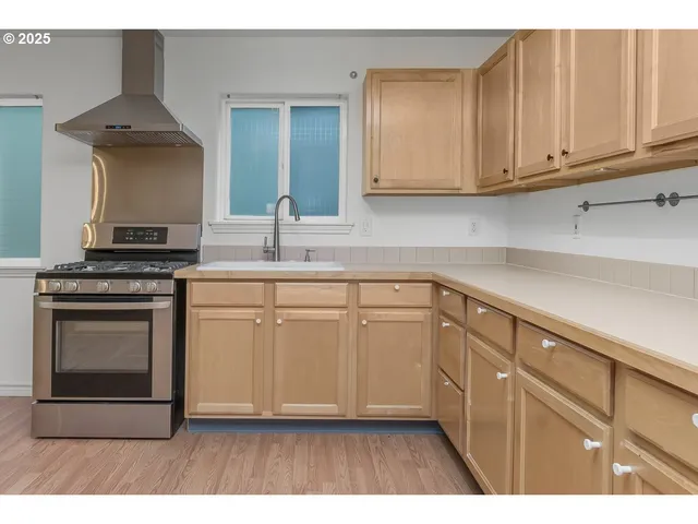 a kitchen with stainless steel appliances granite countertop a stove a sink and a refrigerator