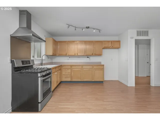 a kitchen with cabinets appliances and a sink
