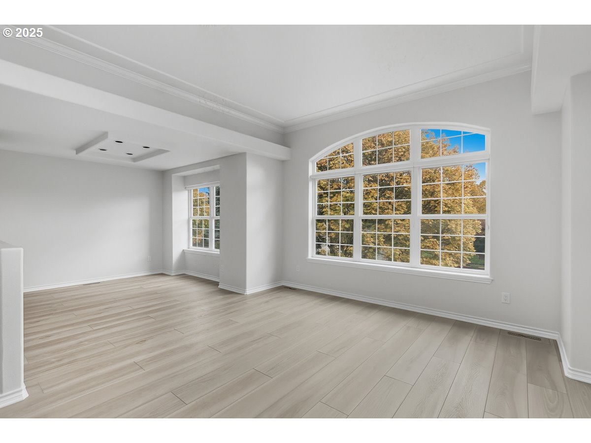 3379 Northwest Banff Drive Portland, OR 97229 - Photo 6 of 26 a view of an empty room with a window and wooden floor