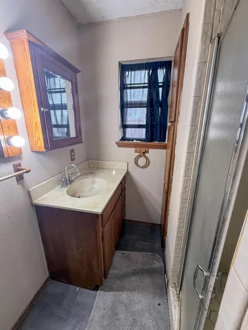 a bathroom with a sink mirror and window