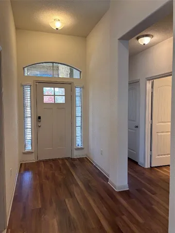 a view of a hallway with wooden floor and stairs