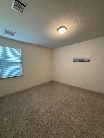 a view of a room with a ceiling fan and window