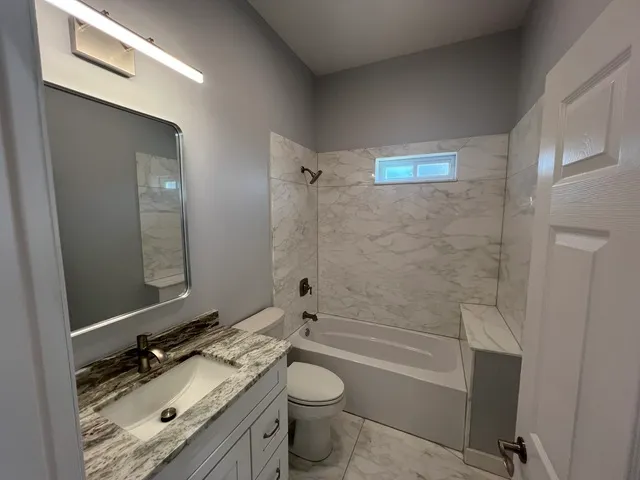 a bathroom with a double vanity sink toilet mirror and shower