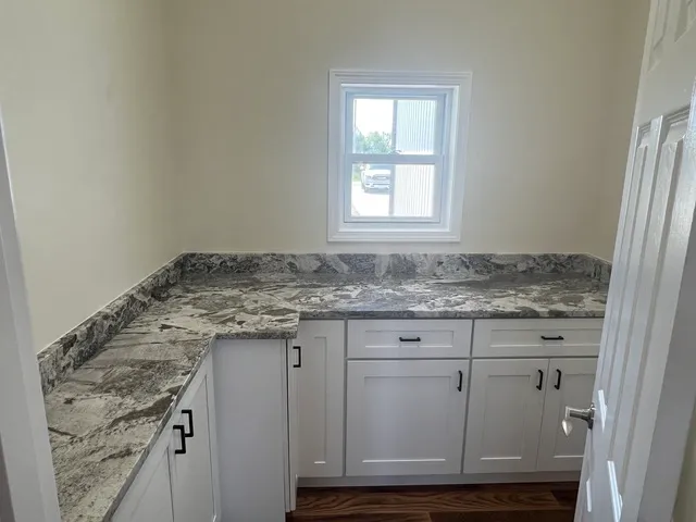 a bathroom with granite countertop cabinets and sink