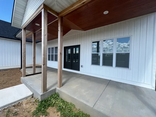 a view of a hallway with wooden floor and a ceiling fan