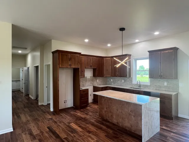 a kitchen with stainless steel appliances granite countertop a sink a refrigerator and a oven