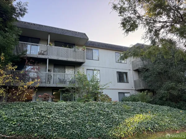 a view of house with a large window and potted plants