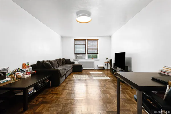 a living room with furniture a window and a flat screen tv
