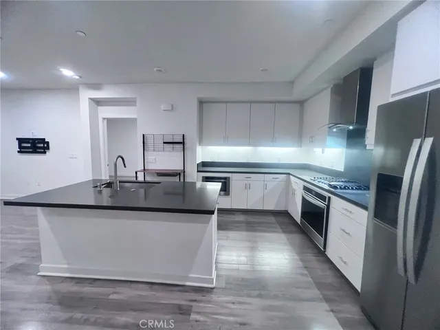 a large kitchen with granite countertop a sink and stainless steel appliances