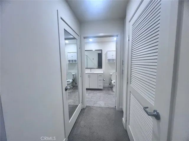 a view of a hallway with wooden shelves