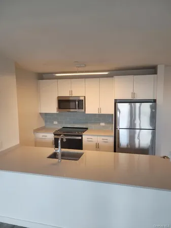 a kitchen with kitchen island a stove a sink and a refrigerator