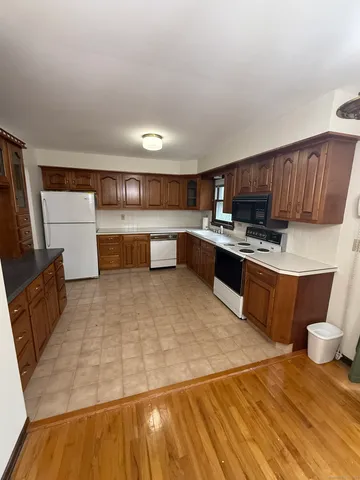 a large kitchen with stainless steel appliances kitchen island granite countertop a refrigerator stove a sink and dishwasher
