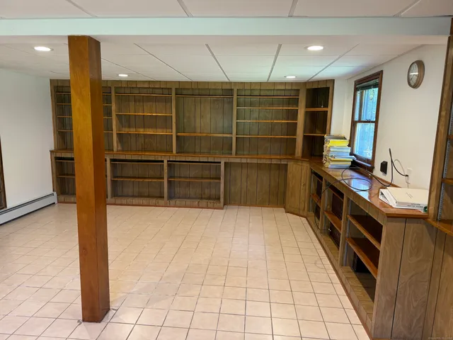 a view of kitchen with refrigerator and white cabinets