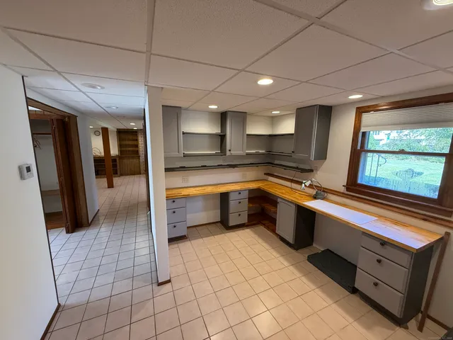 a large kitchen with a large counter top stainless steel appliances and cabinets