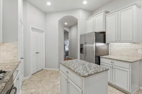 a kitchen with stainless steel appliances granite countertop a refrigerator and a sink